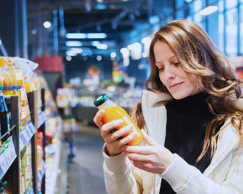 woman reading label into supermarket
