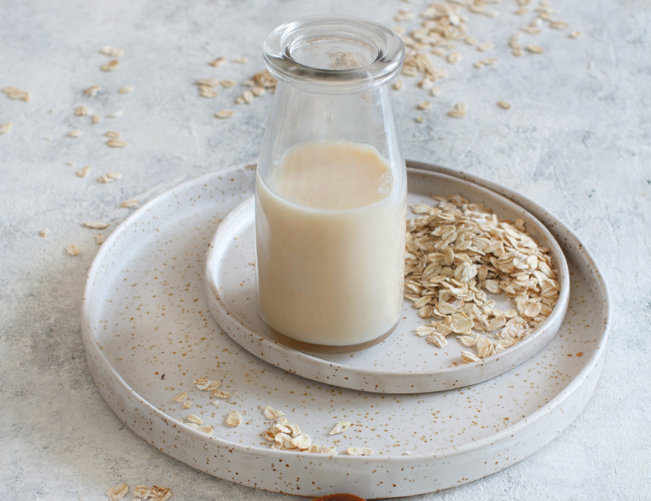 bicchiere con bevanda vegetale di avena su due piatti